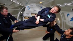 Fisikawan terkemuka Stephen Hawking (tengah) menikmati gravitasi nol selama penerbangan dengan pesawat Boeing 727 yang dimodifikasi milik Zero Gravity Corp. (Zero G). Hawking, yang menderita amyotrophic lateral sclerosis (juga dikenal sebagai penyakit Lou Gehrig) sedang diputar di udara oleh (kanan) Peter Diamandis, pendiri Zero G Corp., dan (kiri) Byron Lichtenberg, mantan spesialis muatan pesawat ulang-alik dan sekarang presiden Zero G. Berlutut di bawah Hawking adalah Nicola O'Brien, seorang praktisi perawat yang merupakan ajudan Hawking. Pada perayaan ulang tahunnya yang ke-65 pada tanggal 8 Januari 2007, Hawking mengumumkan rencananya untuk penerbangan tanpa gravitasi untuk mempersiapkan penerbangan luar angkasa sub-orbital pada tahun 2009 pada layanan luar angkasa Virgin Galactic. (Foto: Jim Campbell/Aero-News Network)