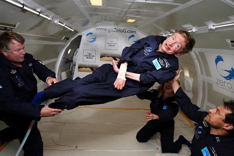 Fisikawan terkemuka Stephen Hawking (tengah) menikmati gravitasi nol selama penerbangan dengan pesawat Boeing 727 yang dimodifikasi milik Zero Gravity Corp. (Zero G). Hawking, yang menderita amyotrophic lateral sclerosis (juga dikenal sebagai penyakit Lou Gehrig) sedang diputar di udara oleh (kanan) Peter Diamandis, pendiri Zero G Corp., dan (kiri) Byron Lichtenberg, mantan spesialis muatan pesawat ulang-alik dan sekarang presiden Zero G. Berlutut di bawah Hawking adalah Nicola O'Brien, seorang praktisi perawat yang merupakan ajudan Hawking. Pada perayaan ulang tahunnya yang ke-65 pada tanggal 8 Januari 2007, Hawking mengumumkan rencananya untuk penerbangan tanpa gravitasi untuk mempersiapkan penerbangan luar angkasa sub-orbital pada tahun 2009 pada layanan luar angkasa Virgin Galactic. (Foto: Jim Campbell/Aero-News Network)